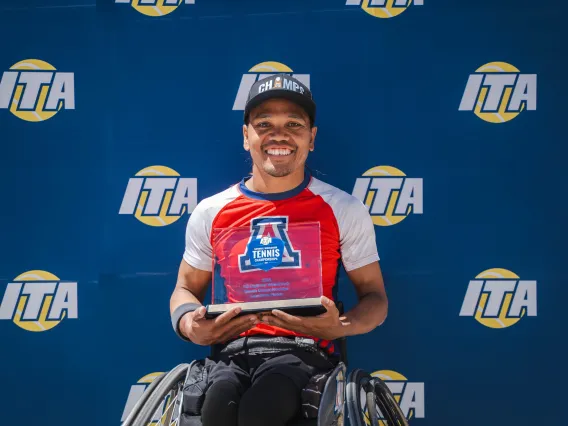 Photo of Den Baseda holding his tennis trophy