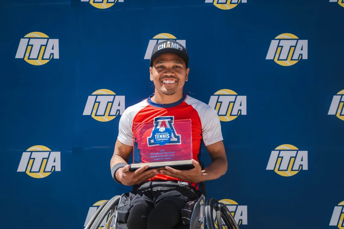 Photo of Den Baseda holding his tennis trophy