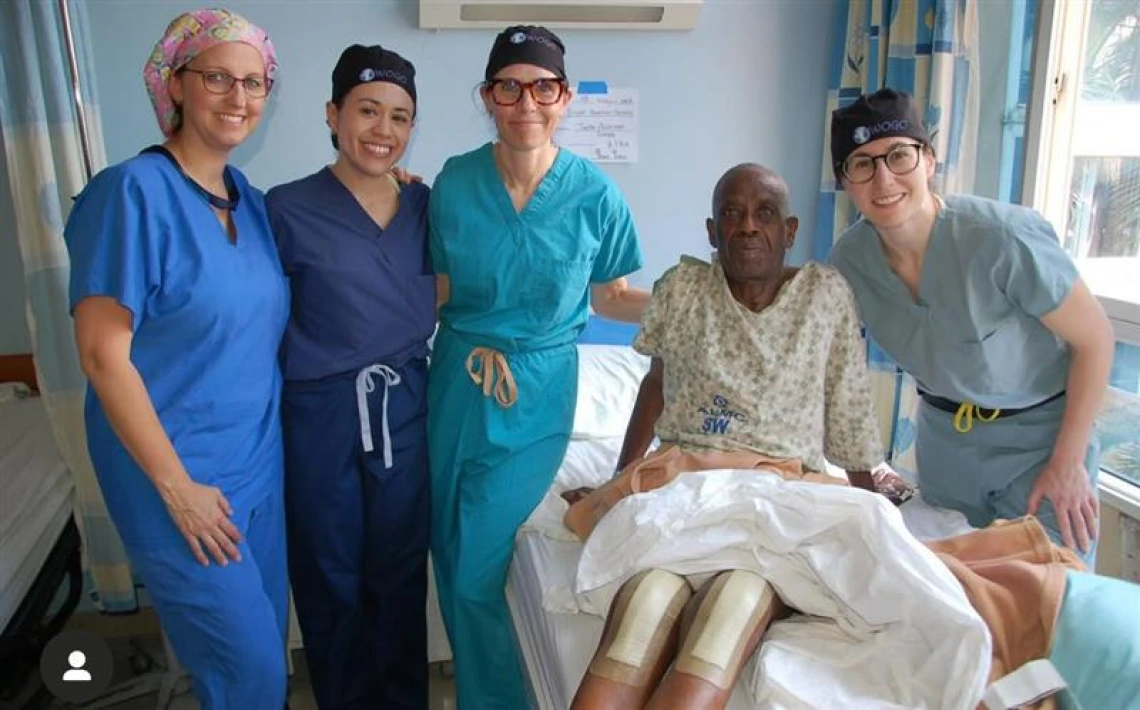Dr. Kim Tucker standing with three colleagues and a knee-surgery patient