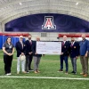 Photo of Banner Sports Medicine and Orthopedics employees and the Tucson Conquistadores holding a donation check